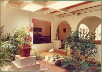 The courtyard on the other side of the corridor. The arches in the corridor are now open thus making it part of the garden as well as the house. The dining room can be seen at the end of the corridor.
